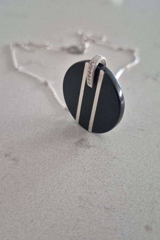 Black and silver circular stone pendant