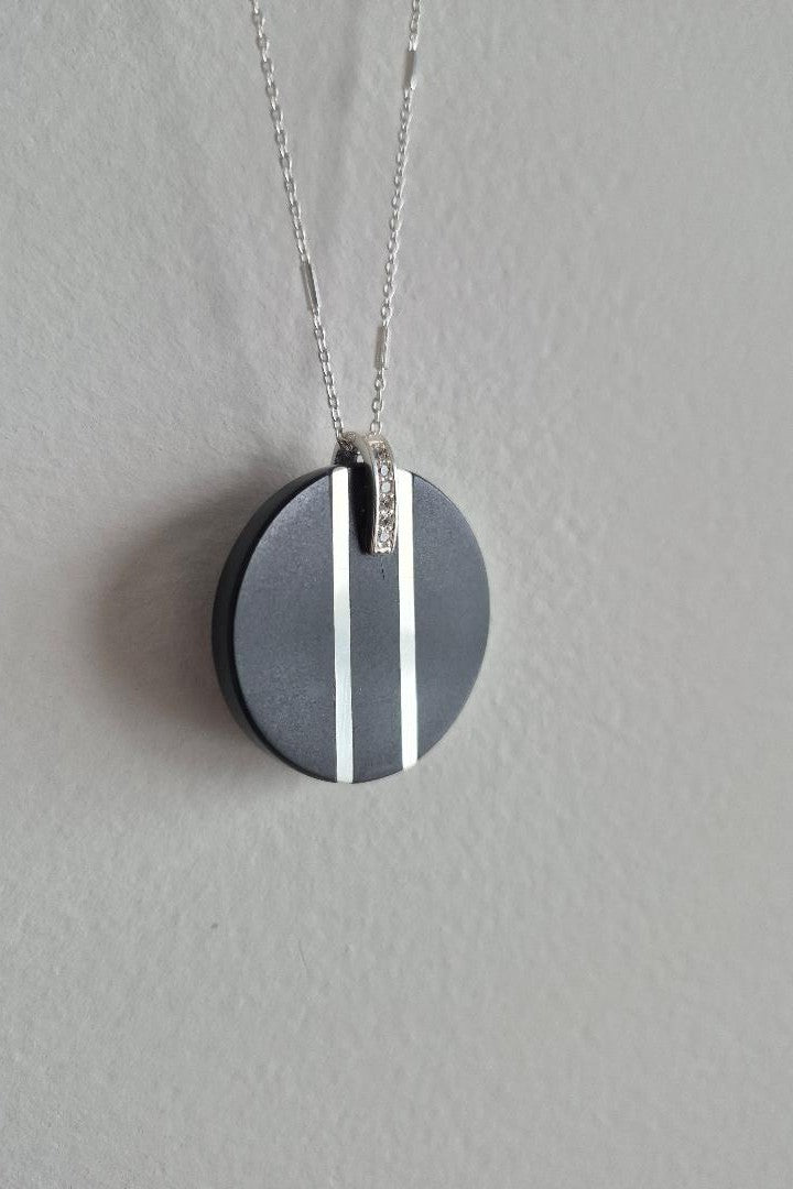 Black and silver circular stone pendant