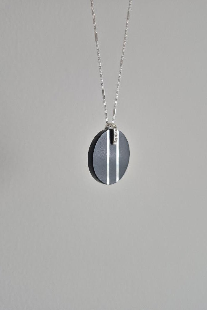 Black and silver circular stone pendant